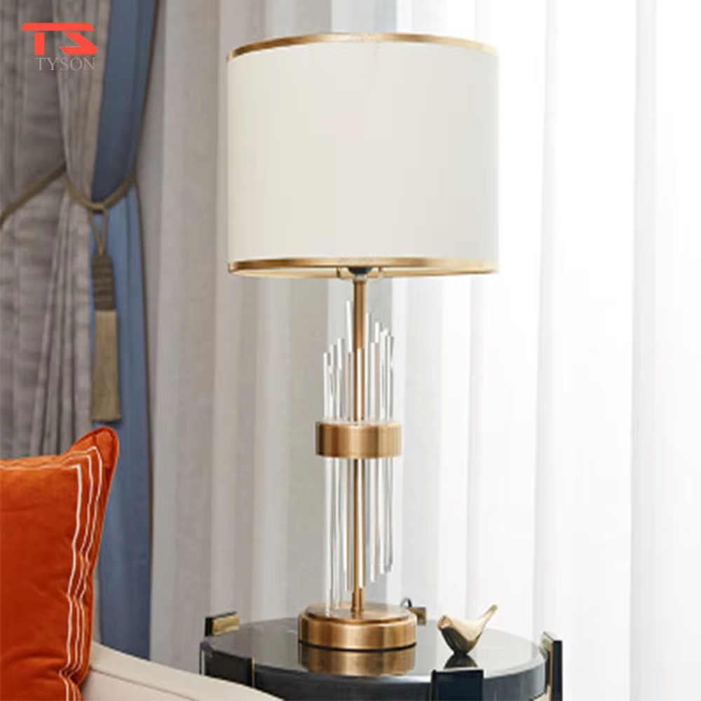 This is a light luxury crystal-metal splicing table lamp, with an off-white fabric lampshade edged with gold trim, a lamp post made of transparent crystal strips and gold metal, and a gold metal base, featuring both decorative and lighting functions, ideal for high-end indoor scenarios such as bedroom nightstands and living room side tables.