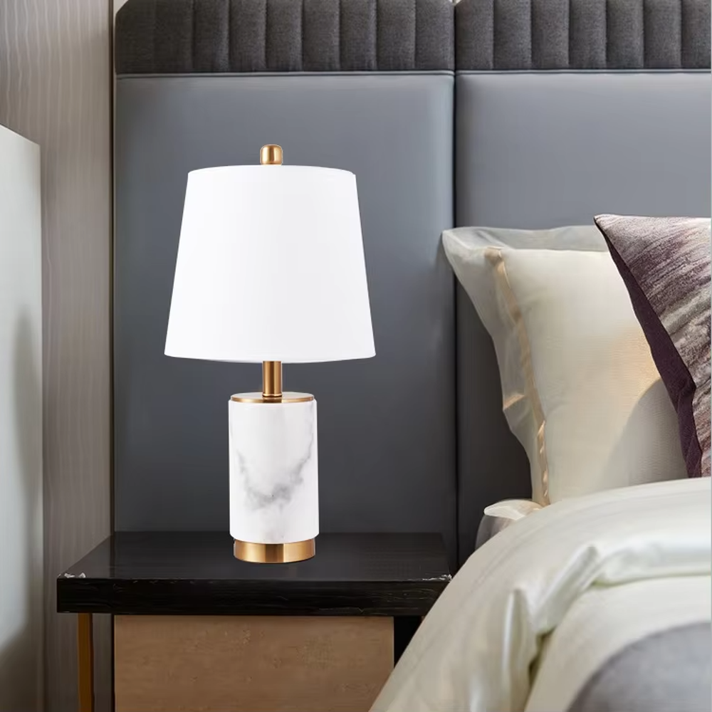 Light luxury white marble cylindrical table lamp, white marble base + golden metal decorations + beige fabric lampshade, soft warm light, creating an elegant light luxury home atmosphere.