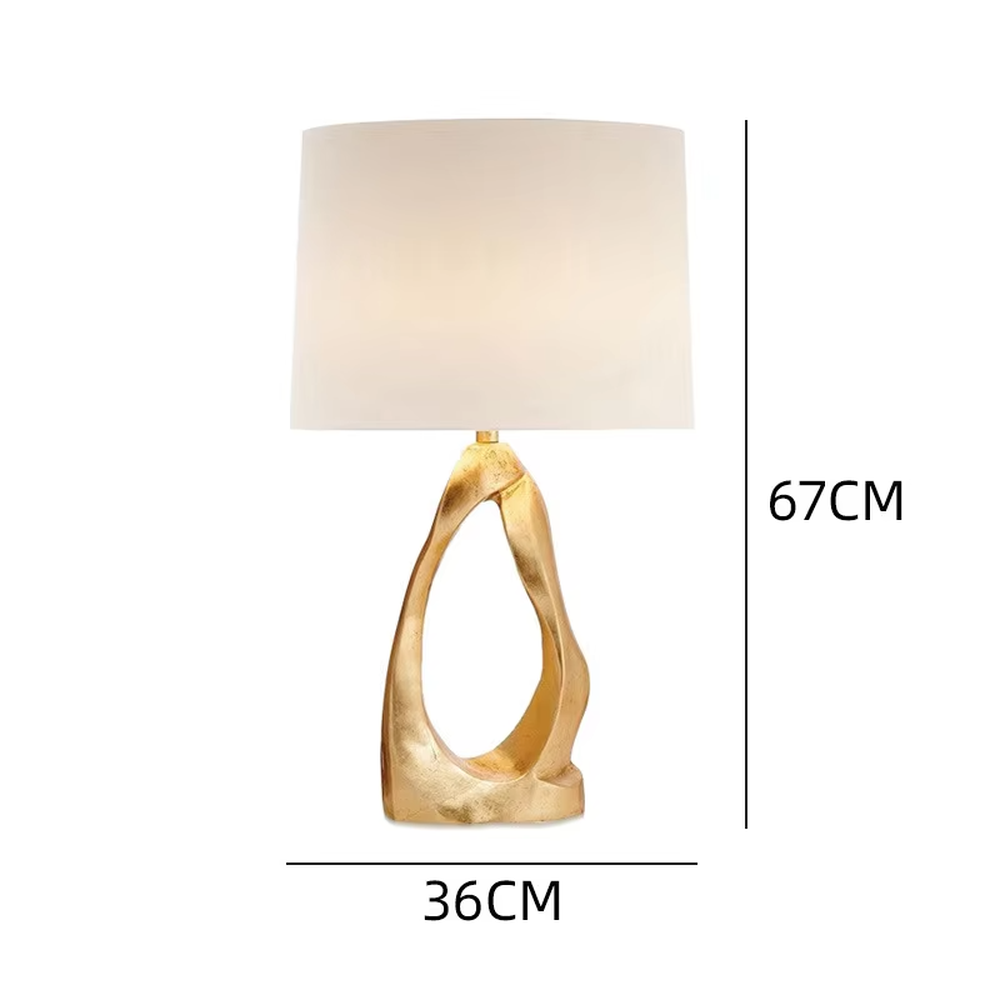 Light luxury art golden twisted hollow base table lamp, irregular metal texture base + beige fabric lampshade, soft warm light, creating a high-end artistic home atmosphere.