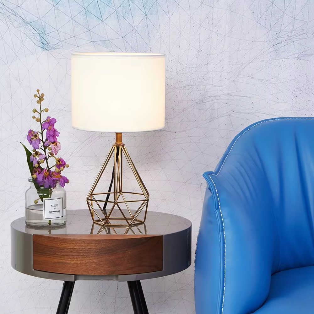 A pair of light luxury geometric iron table lamps, with gold rhombus metal frames and white fabric lampshades, providing soft and eye-protective lighting, used for lighting and decoration in home spaces, suitable for bedroom nightstands, living room side tables, hotel guest rooms, etc.