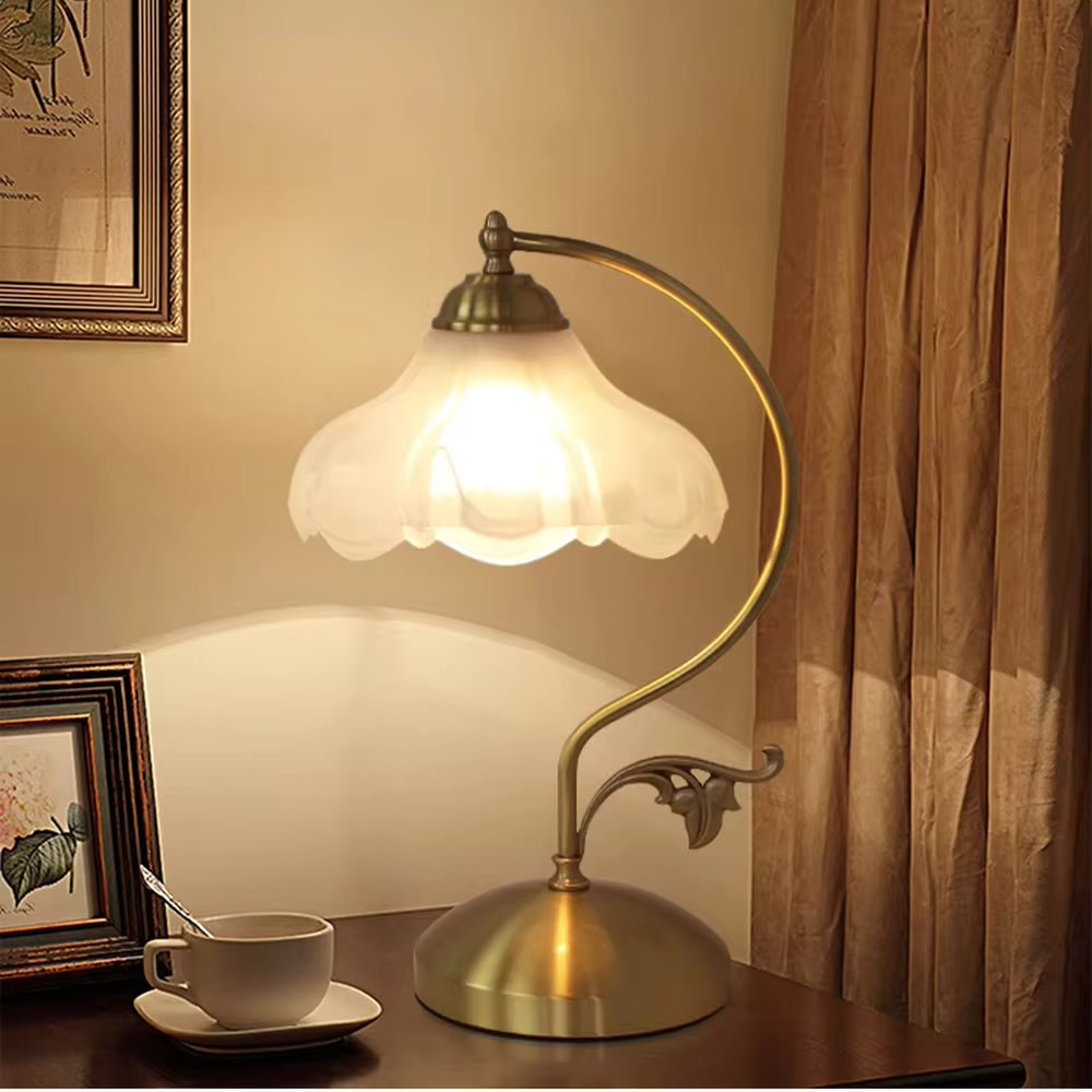 Vintage pastoral style flower-shaped table lamp, with a black wrought iron curved lamp pole with leaf decoration, paired with a white frosted glass petal lampshade. It emits soft and warm light, combining decorativeness and practicality, suitable for lighting and decoration in spaces such as bedroom nightstands, study desks, and B&B guest rooms.