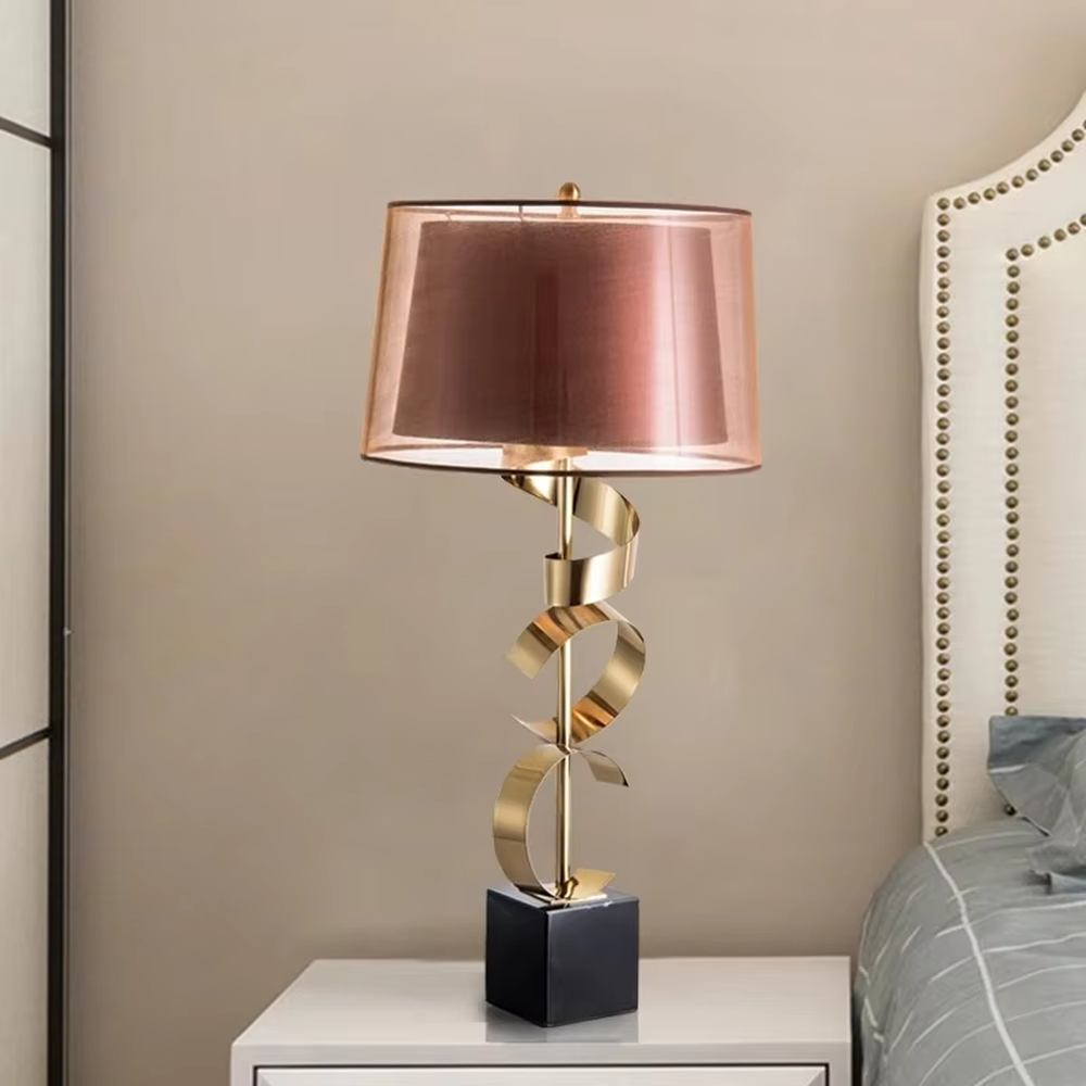 Light luxury spiral metal table lamp (gold spiral pole + pink-brown fabric shade), warm light effect, creating a dynamic and high-end warm space atmosphere.
