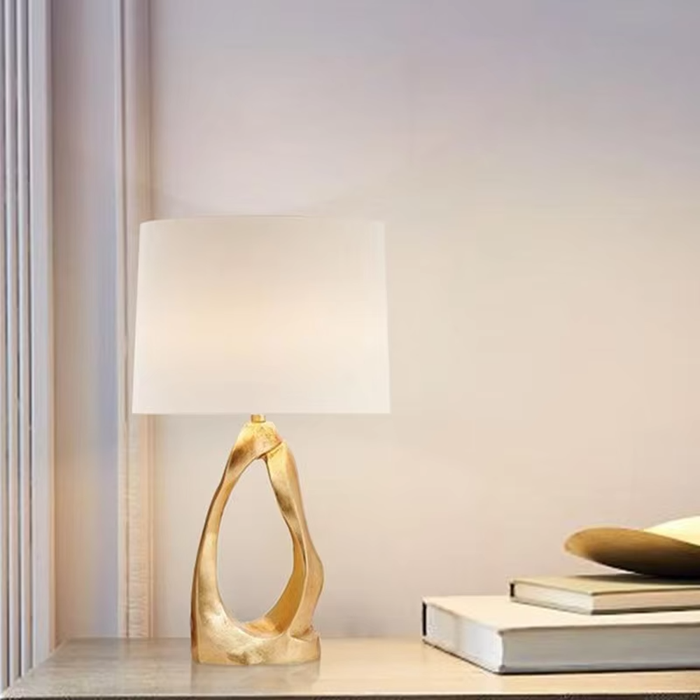Art texture gold base table lamp (irregular gold base + fabric shade), warm light effect, creating an artistic and high-end light luxury home atmosphere.
