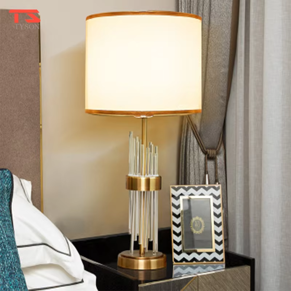 This is a light luxury crystal-metal splicing table lamp, with an off-white fabric lampshade edged with gold trim, a lamp post made of transparent crystal strips and gold metal, and a gold metal base, featuring both decorative and lighting functions, ideal for high-end indoor scenarios such as bedroom nightstands and living room side tables.