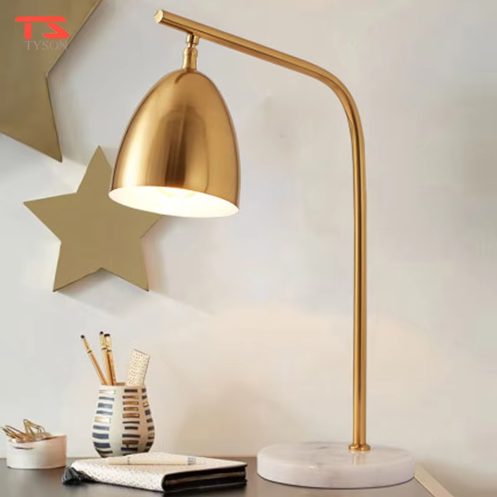 This is a modern light luxury style table lamp, with a gold metal curved arm paired with a dome-shaped lampshade, and a white marble base, which has both lighting and decorative functions, suitable for study desks, bedroom nightstands, office spaces, etc.