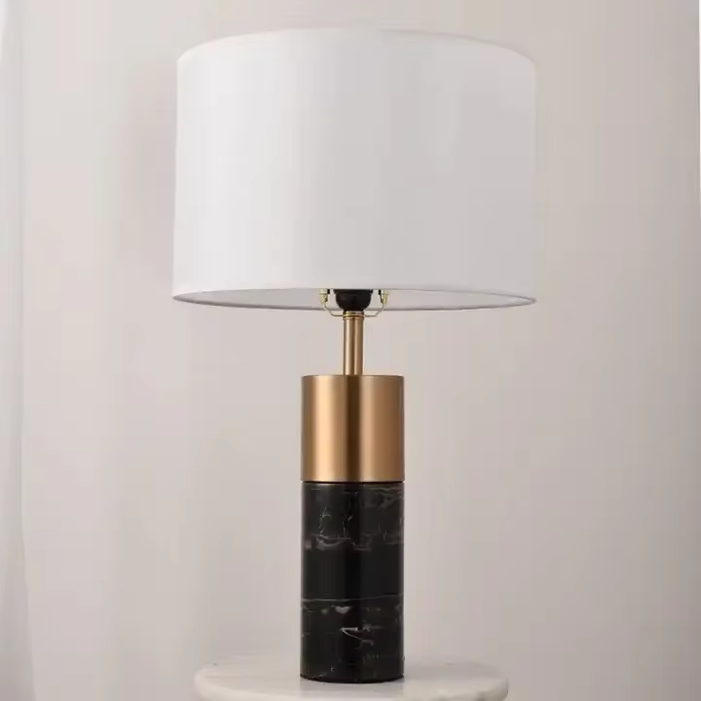 This light luxury modern table lamp features a lamp post made of black marble and gold metal, paired with an off-white fabric cylindrical lampshade. It has a calm and elegant shape, serves both lighting and decorative purposes, and is ideal for bedroom bedside tables, living room side tables, hotel guest rooms and light luxury commercial spaces.