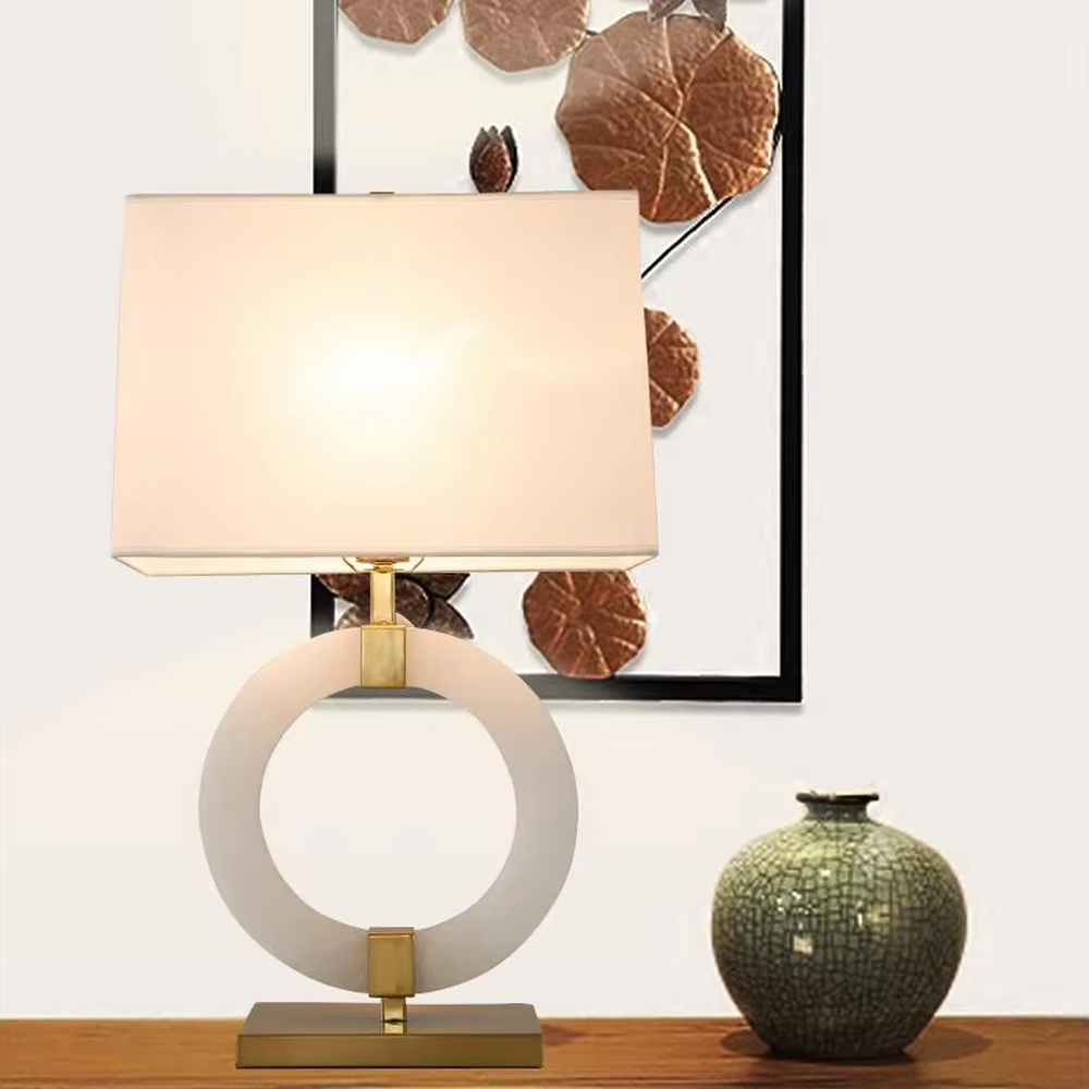 Light luxury white jade ring base table lamp, white jade-textured ring + golden metal decorations + white fabric lampshade, soft warm light, creating a light luxury elegant home atmosphere.