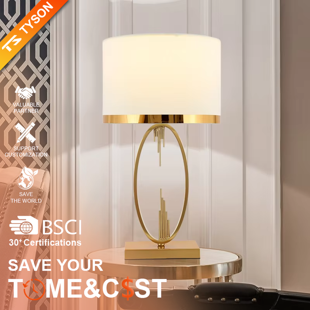 Light luxury style gold metal table lamp, featuring an oval hollow frame with pendant line decorations, paired with an off-white fabric lampshade with a gold trim at the bottom. It emits soft and elegant light, combining artistic decorativeness and lighting practicality, suitable for atmosphere creation and embellishment in bedrooms, living rooms, hotels and other spaces.