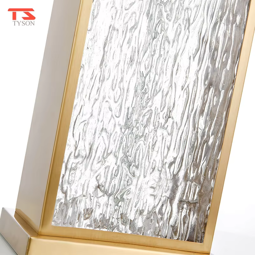 This modern light luxury table lamp features a gold metal frame, paired with a water-textured transparent glass lamp body and a white fabric rectangular lampshade. It serves both lighting and decorative purposes, ideal for light luxury spaces such as bedroom bedside tables, living room side tables, and hotel guest rooms.