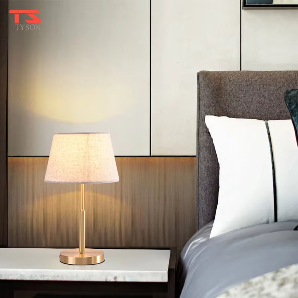 Modern light luxury golden metal pole linen texture fabric shade round base table lamp, warm light effect, creating an elegant minimalist home atmosphere.