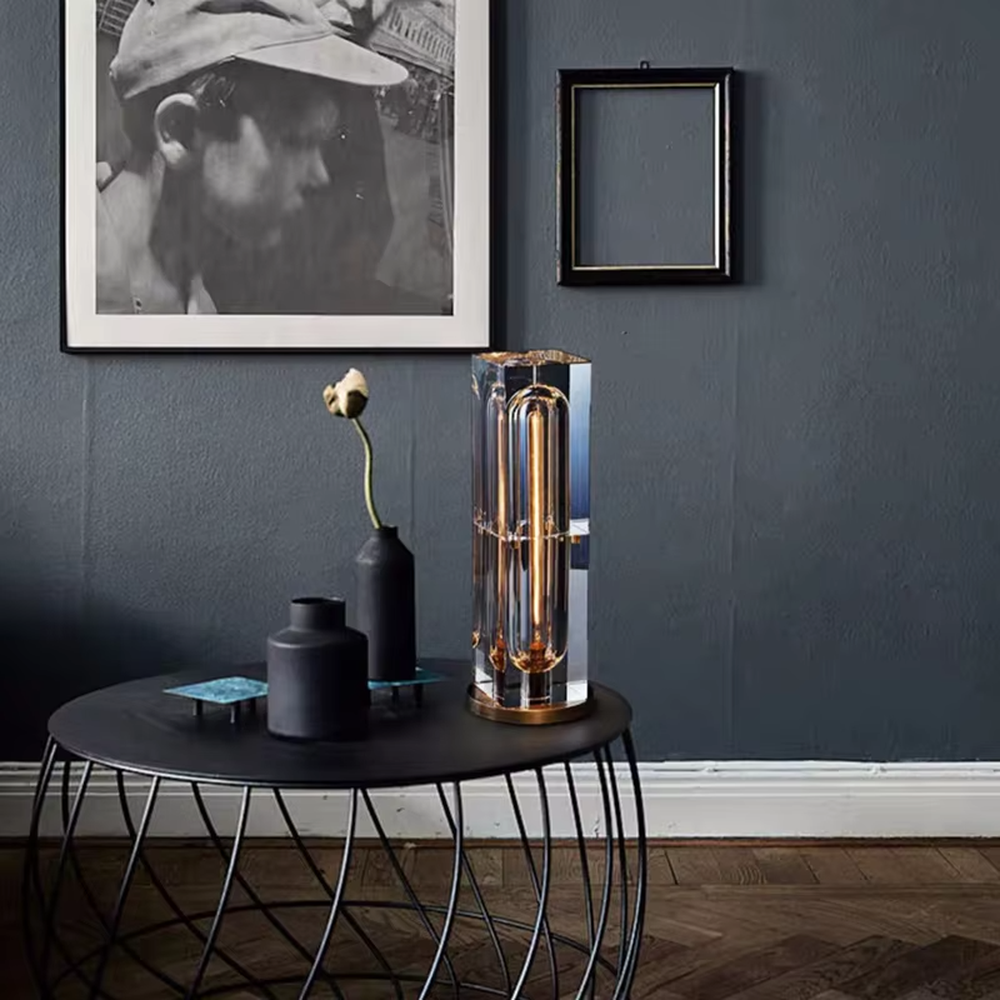 Modern light luxury transparent square column crystal shade gold base Edison bulb table lamp, warm light effect, creating a retro luxurious atmosphere.