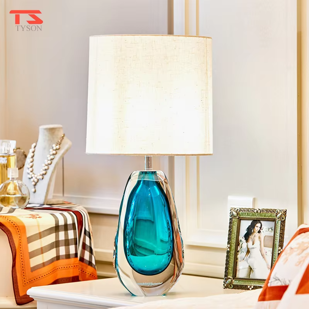 This is a fresh light luxury glass table lamp, with a royal blue fabric lampshade paired with a blue-green gradient hand-blown glass base, featuring both decorative and lighting functions, ideal for warm indoor scenarios such as bedroom nightstands and living room side tables.