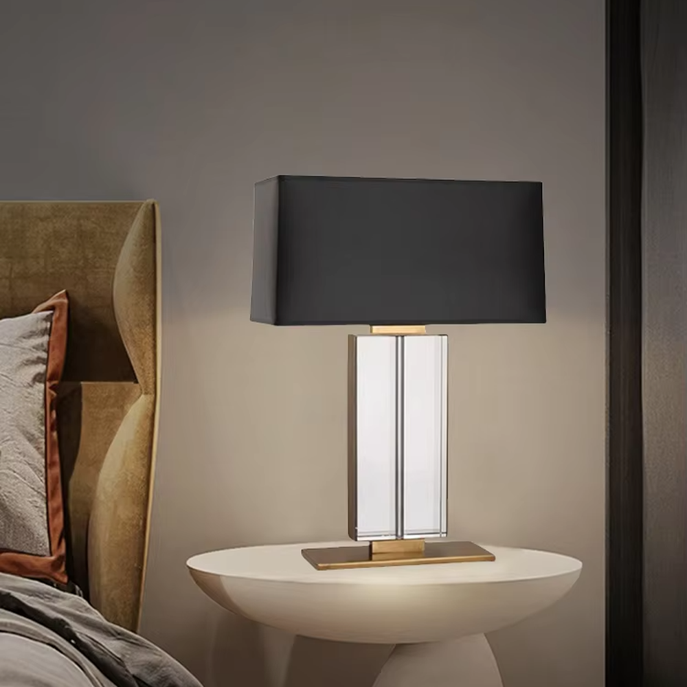 This is a modern light luxury crystal column table lamp, with a black rectangular fabric lampshade paired with a transparent cut crystal column base, accented with gold metal details, featuring both decorative and lighting functions, ideal for high-end indoor scenarios such as living room side tables and bedroom nightstands.