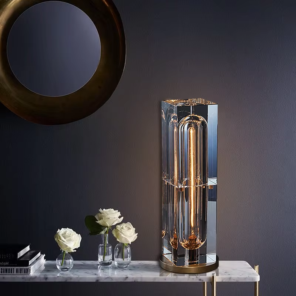 Modern light luxury crystal column table lamp, with a transparent cut crystal outer frame paired with a central gold metal luminous body, and a gold metal base at the bottom, emitting soft and transparent light, combining decorativeness and practicality, suitable for lighting and decoration in spaces such as console tables, living room side tables, study desks, and hotel guest rooms.