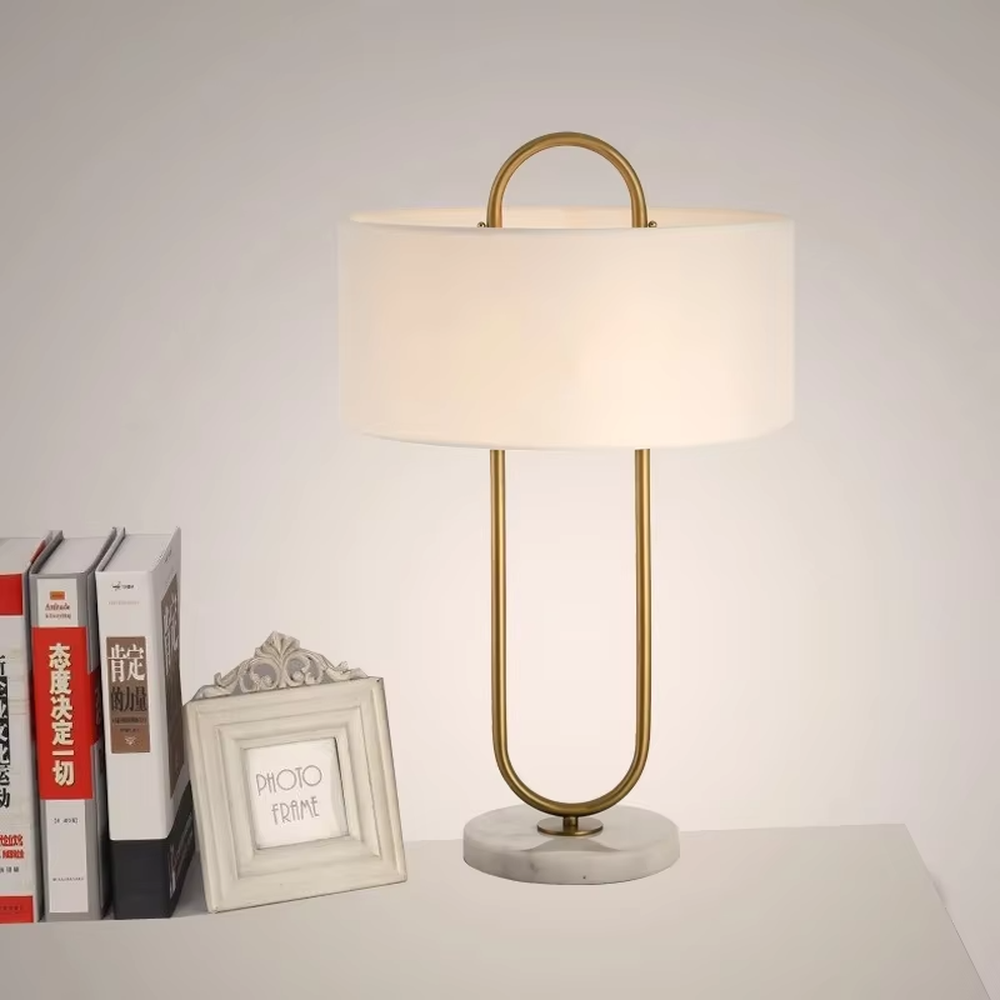 Light luxury U-shaped gold frame table lamp (gold ring stand + fabric shade + marble base), warm light effect, creating an elegant and high-end home atmosphere.