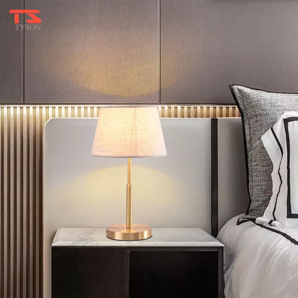 Modern light luxury golden metal pole linen texture fabric shade round base table lamp, warm light effect, creating an elegant minimalist home atmosphere.