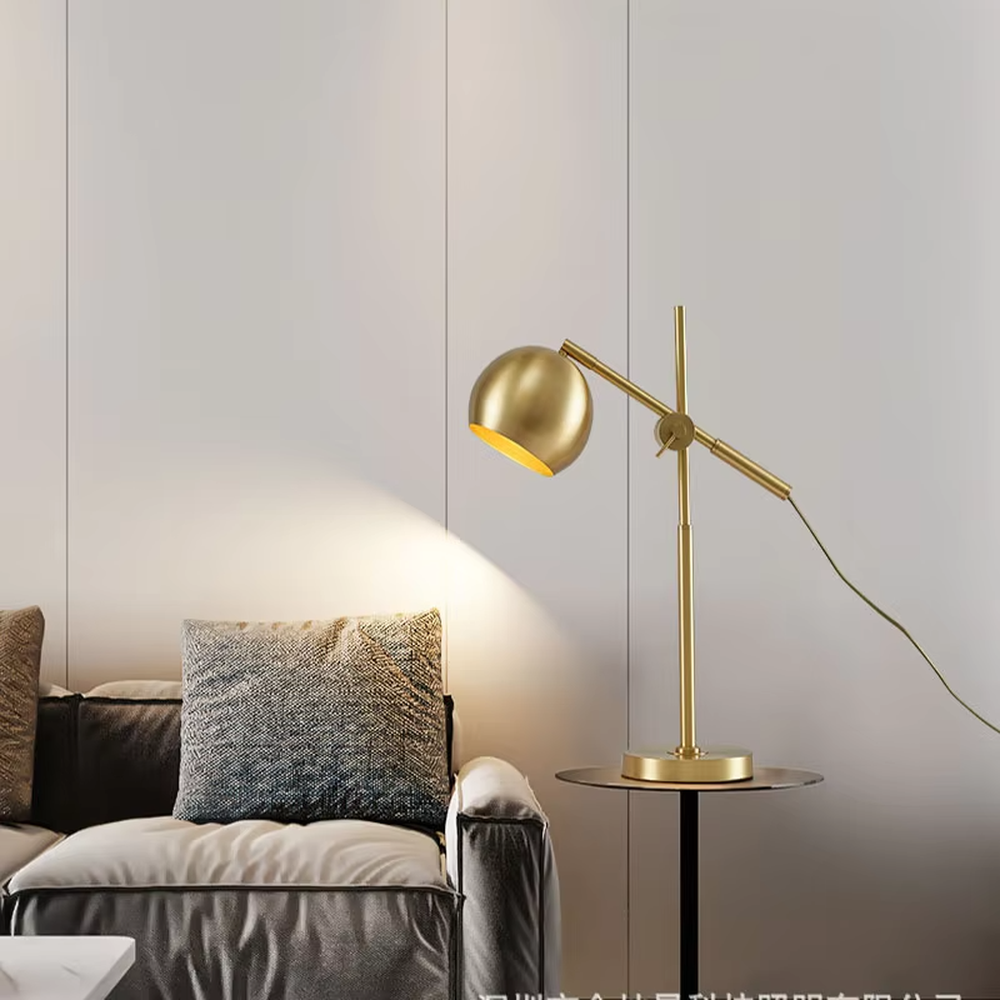 This is a modern light luxury style gold metal table lamp, featuring a spherical lampshade paired with an adjustable long arm and a stable base, which has both lighting and decorative functions, suitable for bedroom nightstands, study desks, hotel guest rooms and other spaces.