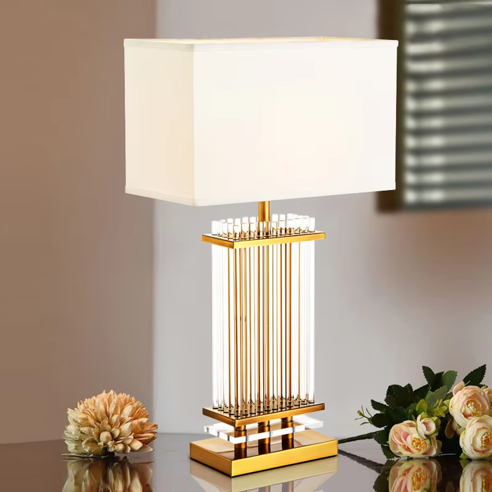 Light luxury gold column crystal table lamp (gold metal vertical strips + crystal lamp post + square fabric lampshade), warm light effect, creating an exquisite and high-end home atmosphere.