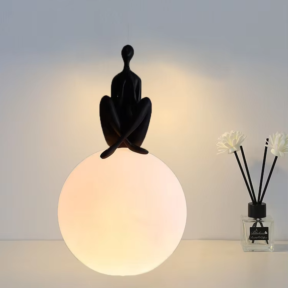 Artistic humanoid sculpture lifting spherical soft light table lamp (black sculpture + warm light ball shade), warm light effect, creating a creative artistic space atmosphere.