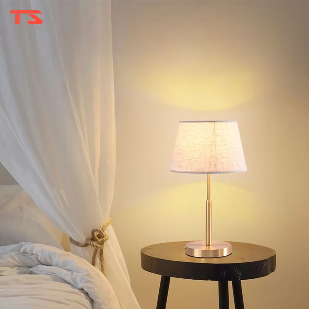 Modern light luxury golden metal pole linen texture fabric shade round base table lamp, warm light effect, creating an elegant minimalist home atmosphere.