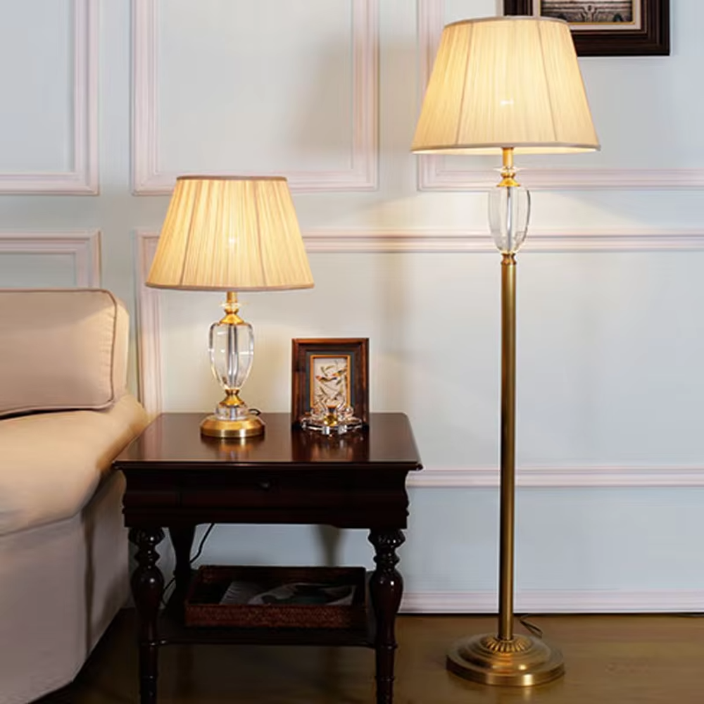 Light luxury crystal table lamp, with a transparent cut crystal column base, gold metal details and a beige pleated fabric lampshade for soft and eye-protective lighting, designed to enhance the elegant atmosphere of spaces, suitable for bedroom nightstands, living room side tables, hotel guest rooms, etc.