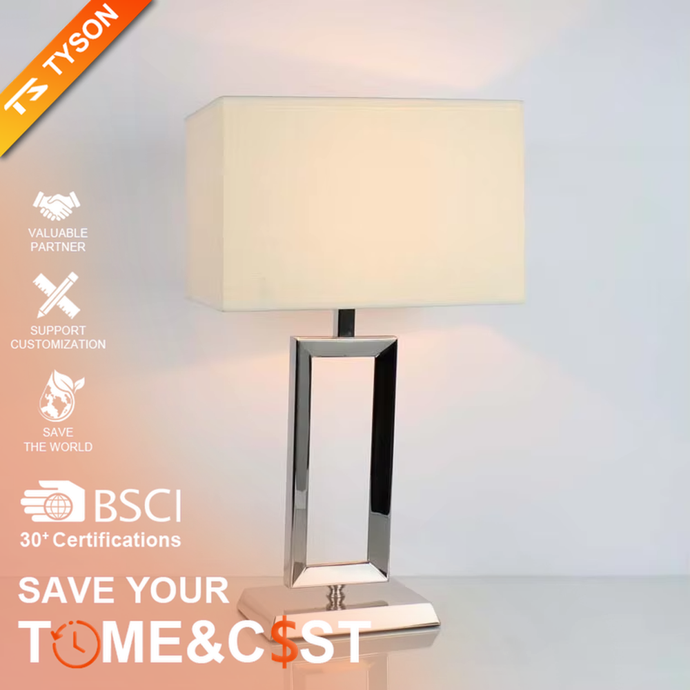 Modern minimalist geometric metal table lamp (bright chrome hollow lamp base + rectangular fabric lampshade), warm light effect, creating an exquisite and high-end home and office atmosphere.