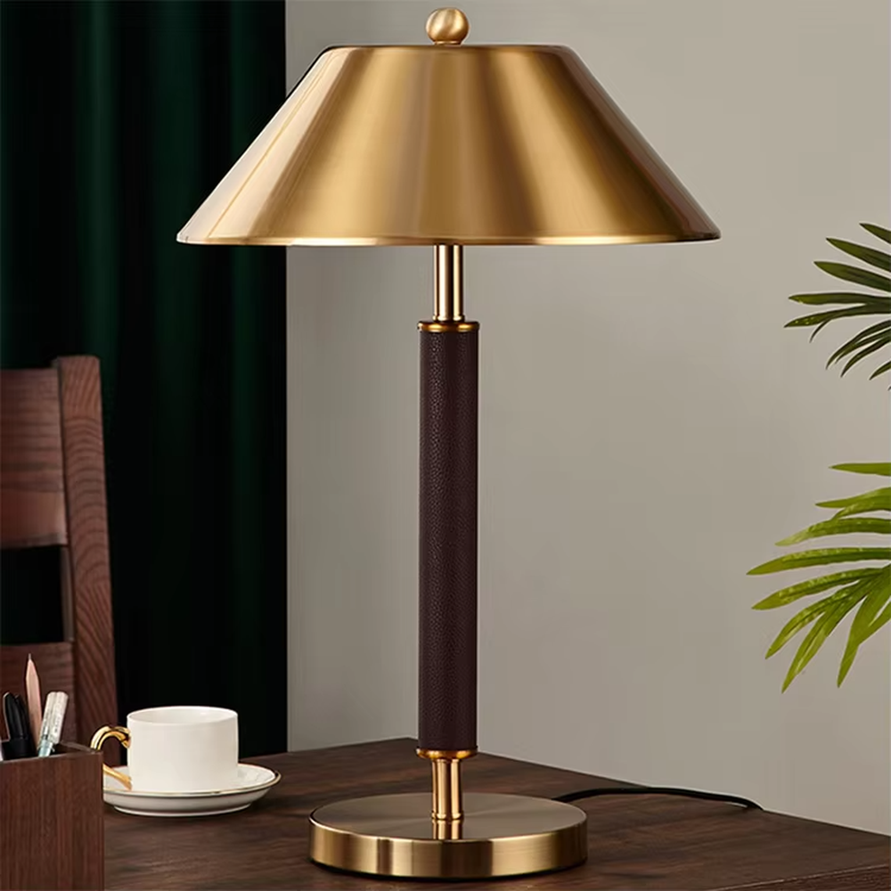 Light luxury gold-brown leather table lamp (gold metal lampshade + dark brown leather lamp post + metal base), warm light effect, creating a retro and high-end office and home atmosphere.