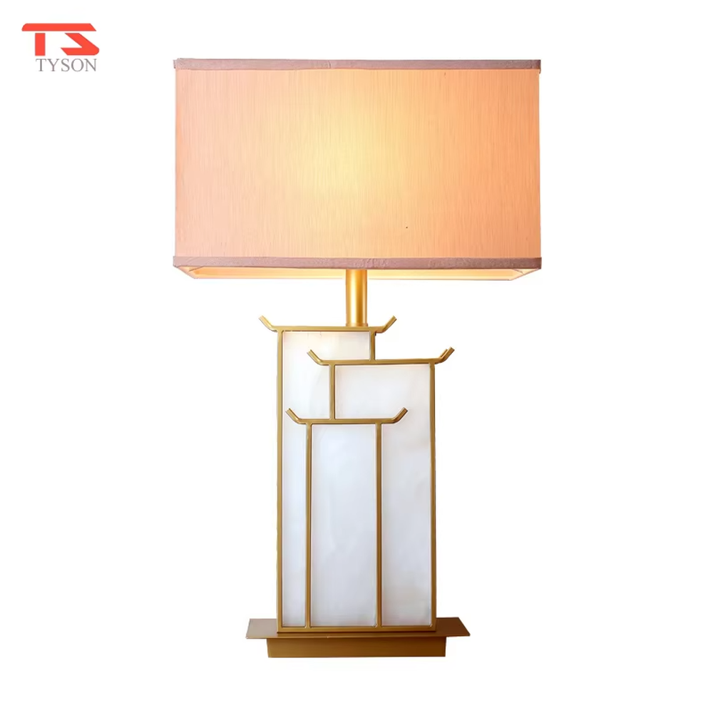 This is a new Chinese style table lamp, featuring a rectangular fabric lampshade paired with a geometric splicing base with Chinese architectural elements, which has both lighting and decorative functions, suitable for bedrooms, studies, tea rooms, new Chinese-style homes and hotel guest rooms and other spaces.