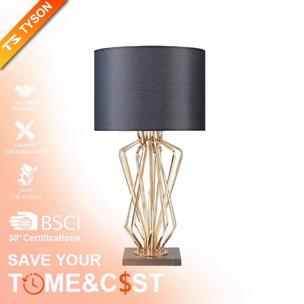 This is a light luxury artistic table lamp, featuring a gold metal geometric hollow lamp body paired with a black marble base and a white fabric lampshade. It emits soft and uniform light, serving both lighting and decorative purposes, suitable for bedroom nightstands, hotel guest rooms, light luxury living room side tables, high-end clubs and other scenarios.