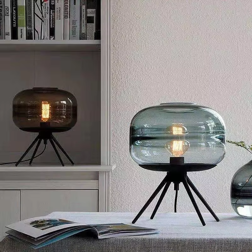 This set of Nordic-style glass lighting includes a table lamp and a chandelier, with drum-shaped lampshades made of blue-gray gradient glass. The table lamp is paired with a black tripod base, and the chandelier uses a suspension design, emitting soft and transparent light, serving both lighting and decorative purposes, ideal for bedrooms, dining rooms, Nordic-style homes and internet-famous shops and other scenarios.