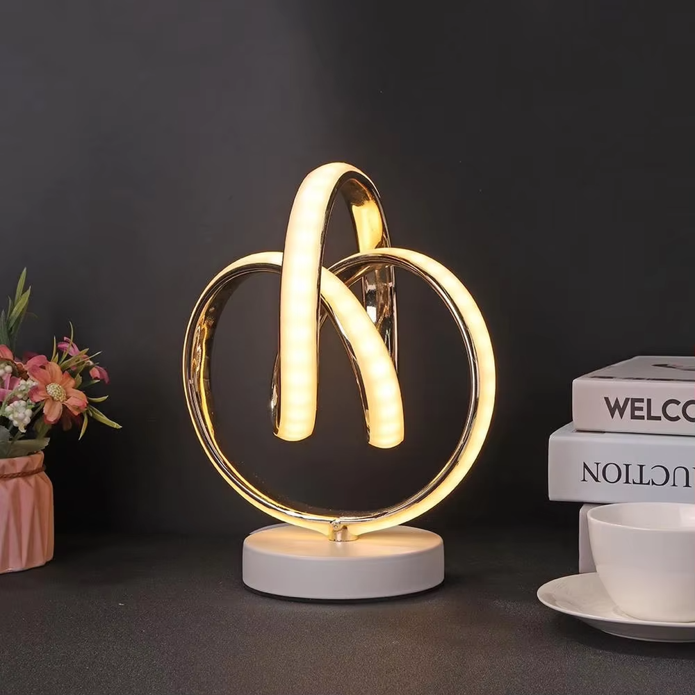 This light luxury art table lamp features a "8"/infinity symbol shape made of gold metal, with embedded LED light strips and a white marble base, serving both lighting and decorative purposes, ideal for living room side tables, bedroom bedside tables, light luxury homestays and other spaces.