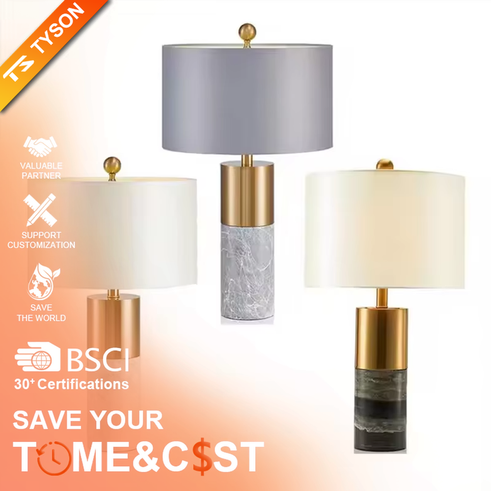 This light luxury table lamp features a black marble (with white veins) base, paired with a gold metal cylindrical lamp body and an off-white fabric cylindrical lampshade, with a gold spherical decoration on top. It serves both lighting and decorative purposes, ideal for light luxury spaces such as bedroom bedside tables, living room side tables, and hotel guest rooms.