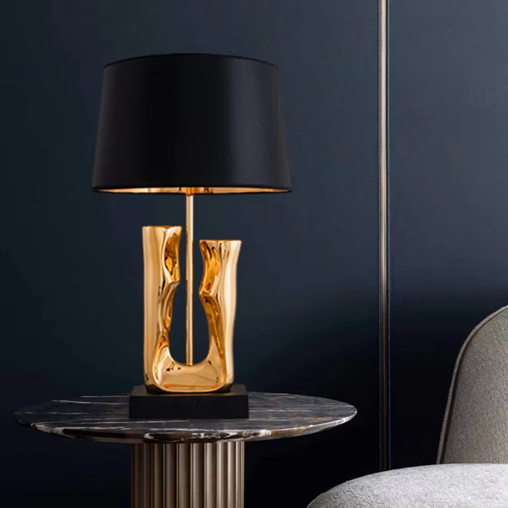 Modern art luxury black-gold sculpture base table lamp, golden streamlined sculpture base + black shade with gold lining + warm light effect, creating a high-end artistic luxury atmosphere.