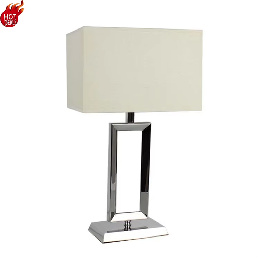 Modern minimalist geometric metal table lamp (bright chrome hollow lamp base + rectangular fabric lampshade), warm light effect, creating an exquisite and high-end home and office atmosphere.