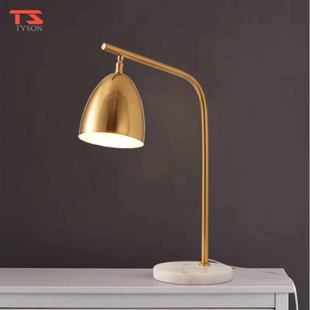 This is a modern light luxury style table lamp, with a gold metal curved arm paired with a dome-shaped lampshade, and a white marble base, which has both lighting and decorative functions, suitable for study desks, bedroom nightstands, office spaces, etc.