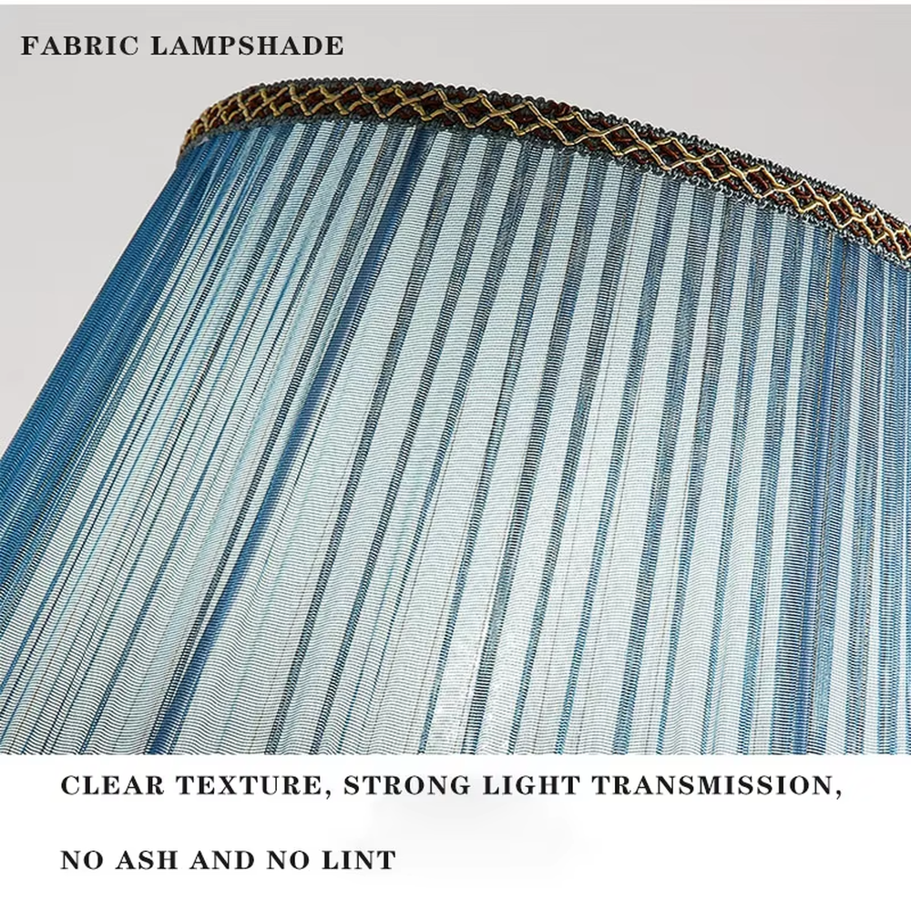 This is a light luxury European-style ceramic table lamp, with a dark blue ceramic base paired with gold metal decorations, and a light blue vertical-striped fabric lampshade edged with a gold ribbon, which has both lighting and decorative functions, suitable for bedroom nightstands, living room side tables, hotel guest rooms and other spaces.