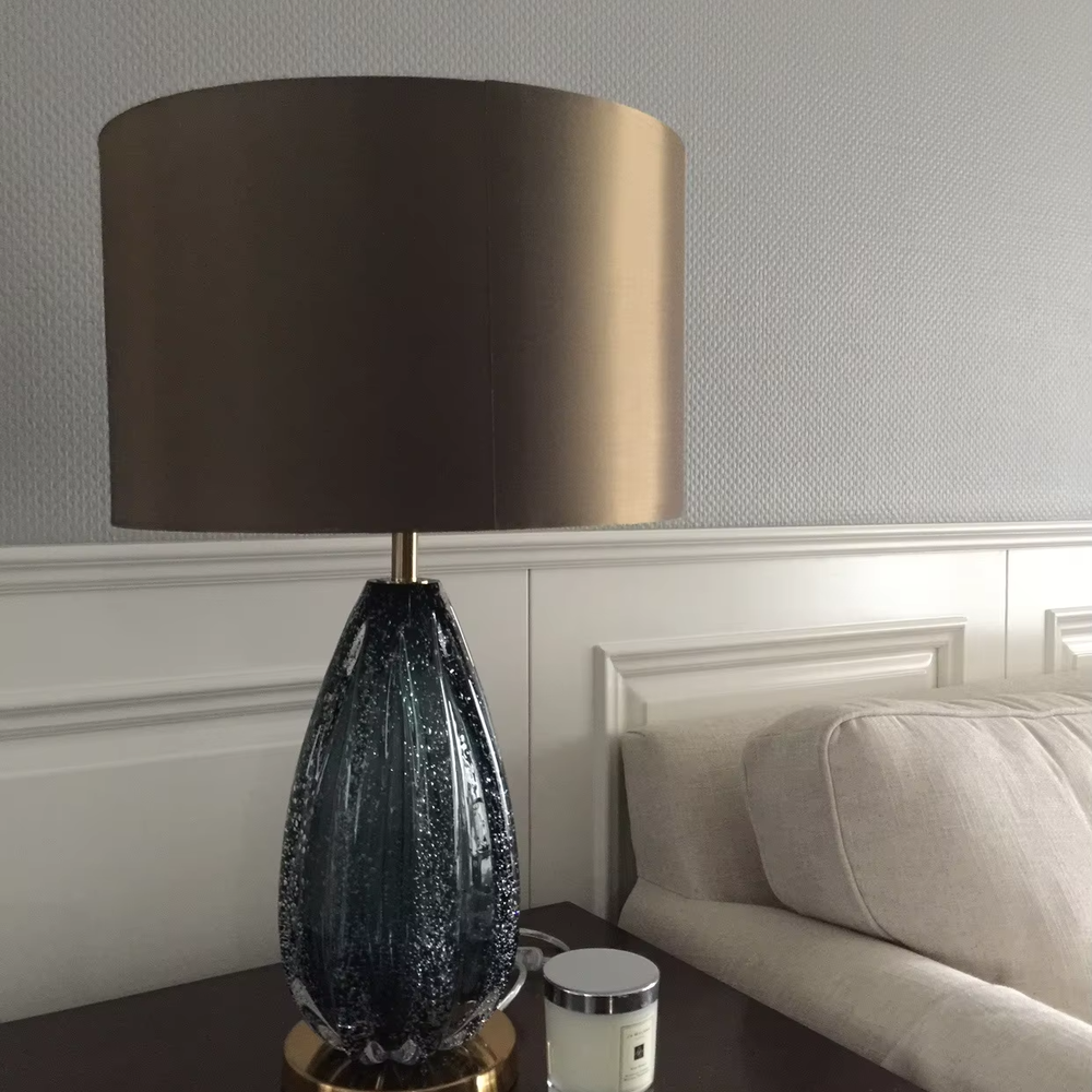 Light luxury textured glass table lamp (dark green glass + metal base), warm light effect, creating an elegant and high-end home space atmosphere.