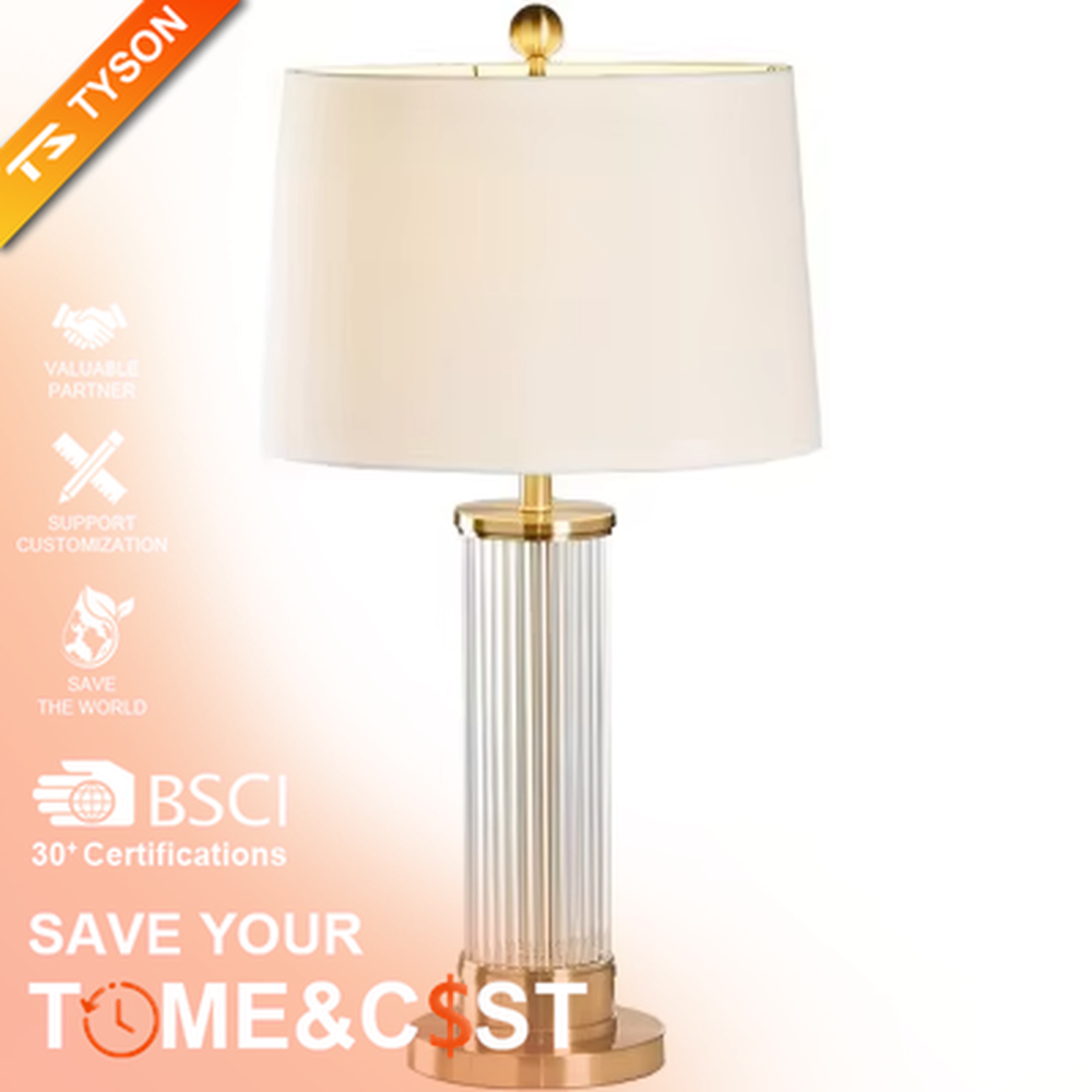 This is a light luxury crystal metal table lamp, with an off-white fabric lampshade edged with gold trim, a lamp post made of vertical striped transparent crystal paired with gold metal splicing, and a gold metal base, featuring both decorative and lighting functions, ideal for high-end indoor scenarios such as bedroom nightstands and living room side tables.