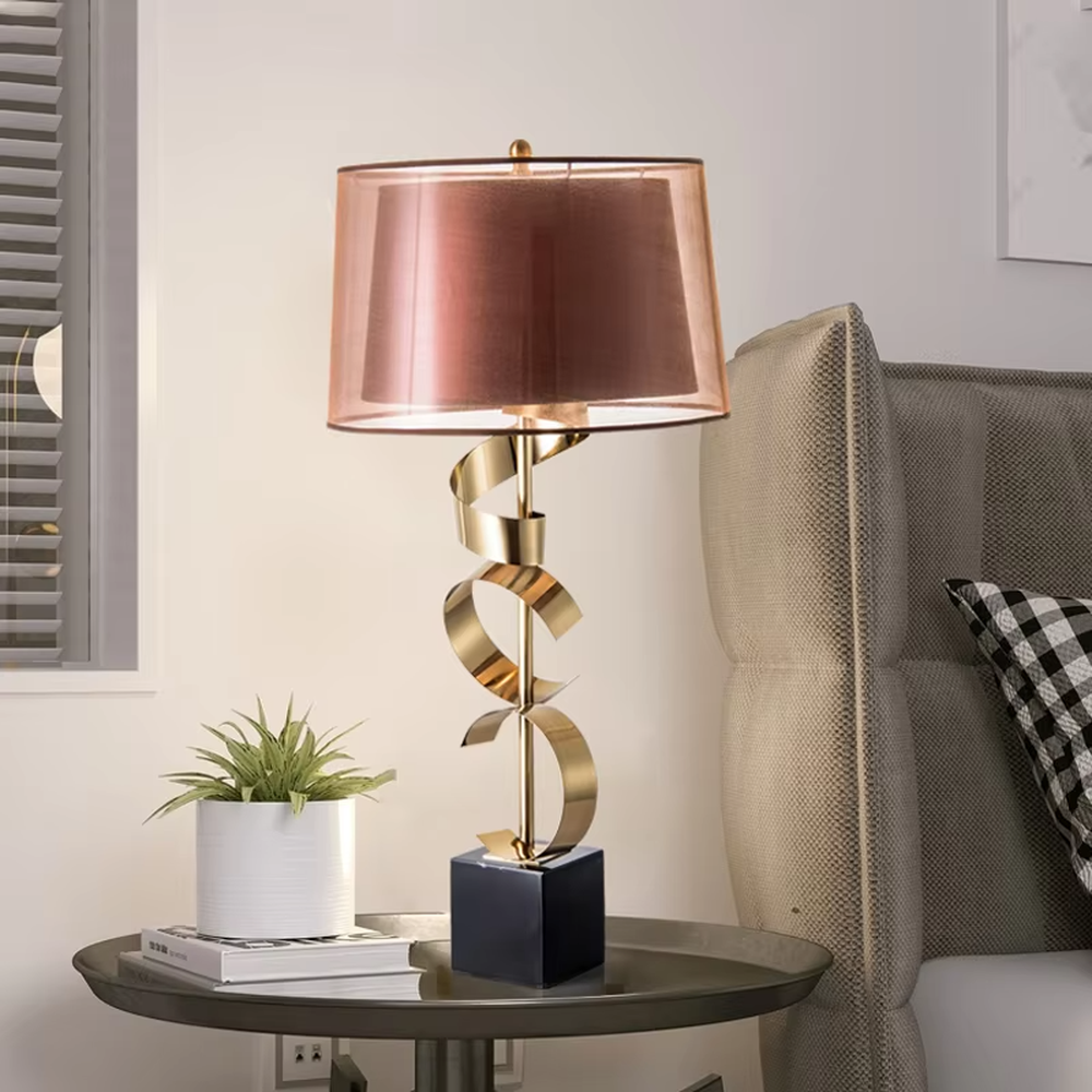 Light luxury golden spiral-shaped table lamp, golden spiral stand + black square base + gradient gray fabric lampshade, soft warm light, creating an elegant light luxury bedroom atmosphere.