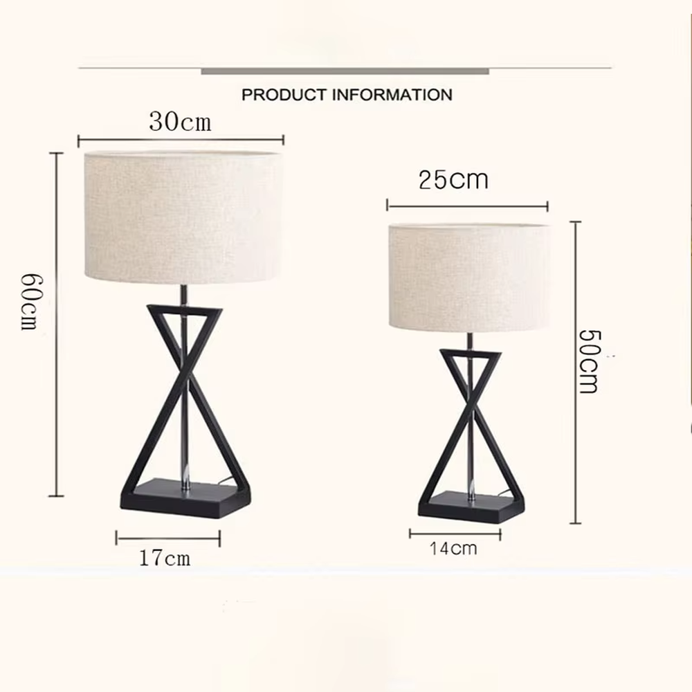 This is a modern minimalist fabric table lamp, featuring an off-white linen lampshade paired with a geometric cross-shaped white and silver dual-color lamp base, which has both lighting and decorative functions, suitable for bedroom nightstands, study desks, hotel guest rooms and other spaces.
