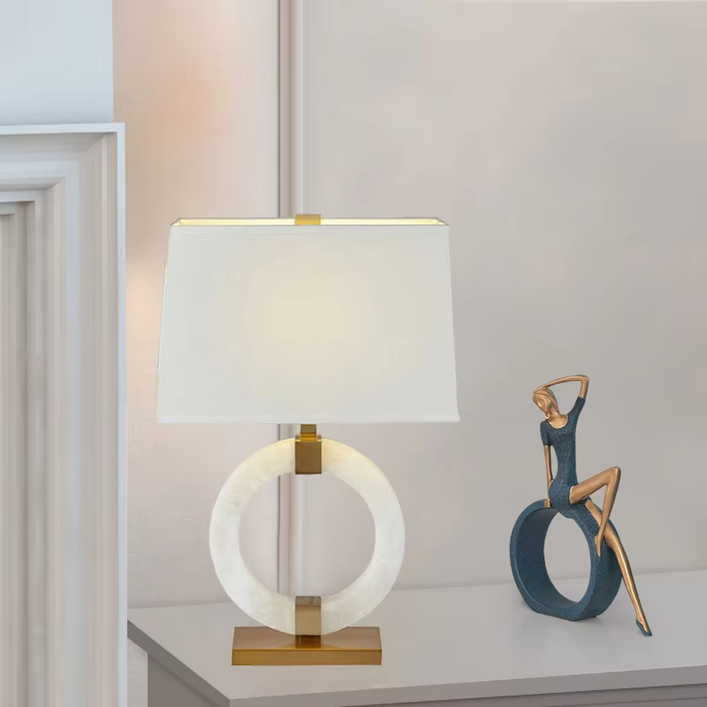 Light luxury white jade ring base table lamp, white jade-textured ring + golden metal decorations + white fabric lampshade, soft warm light, creating a light luxury elegant home atmosphere.