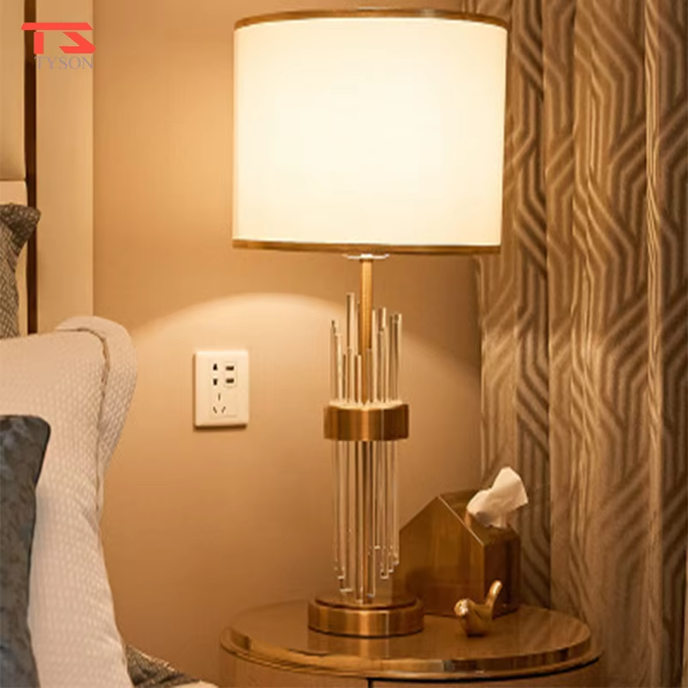 This is a light luxury crystal-metal splicing table lamp, with an off-white fabric lampshade edged with gold trim, a lamp post made of transparent crystal strips and gold metal, and a gold metal base, featuring both decorative and lighting functions, ideal for high-end indoor scenarios such as bedroom nightstands and living room side tables.