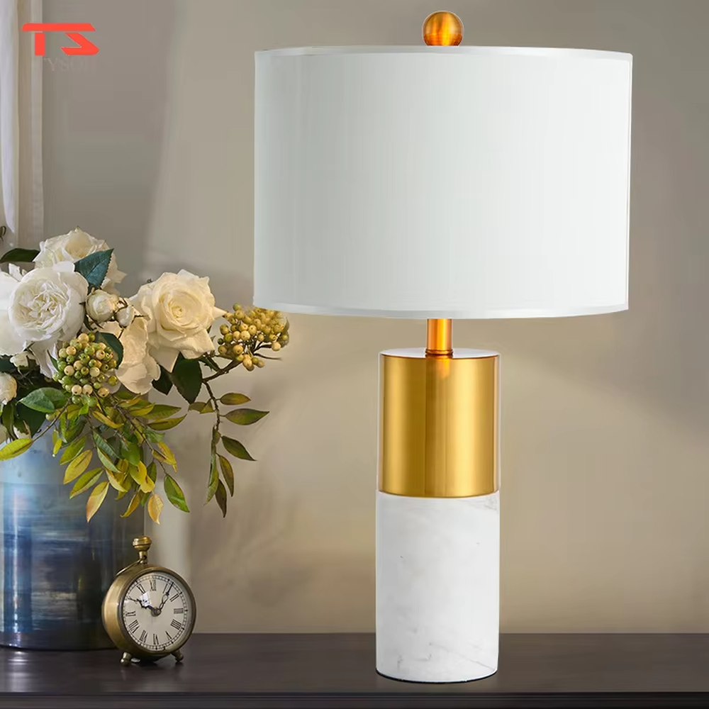 This is a light luxury marble-metal splicing table lamp, with a white fabric lampshade paired with a base made of gold metal and gray marble, accented with an orange decorative ball on top, featuring both decorative and lighting functions, ideal for high-end indoor scenarios such as bedroom nightstands and living room side tables.