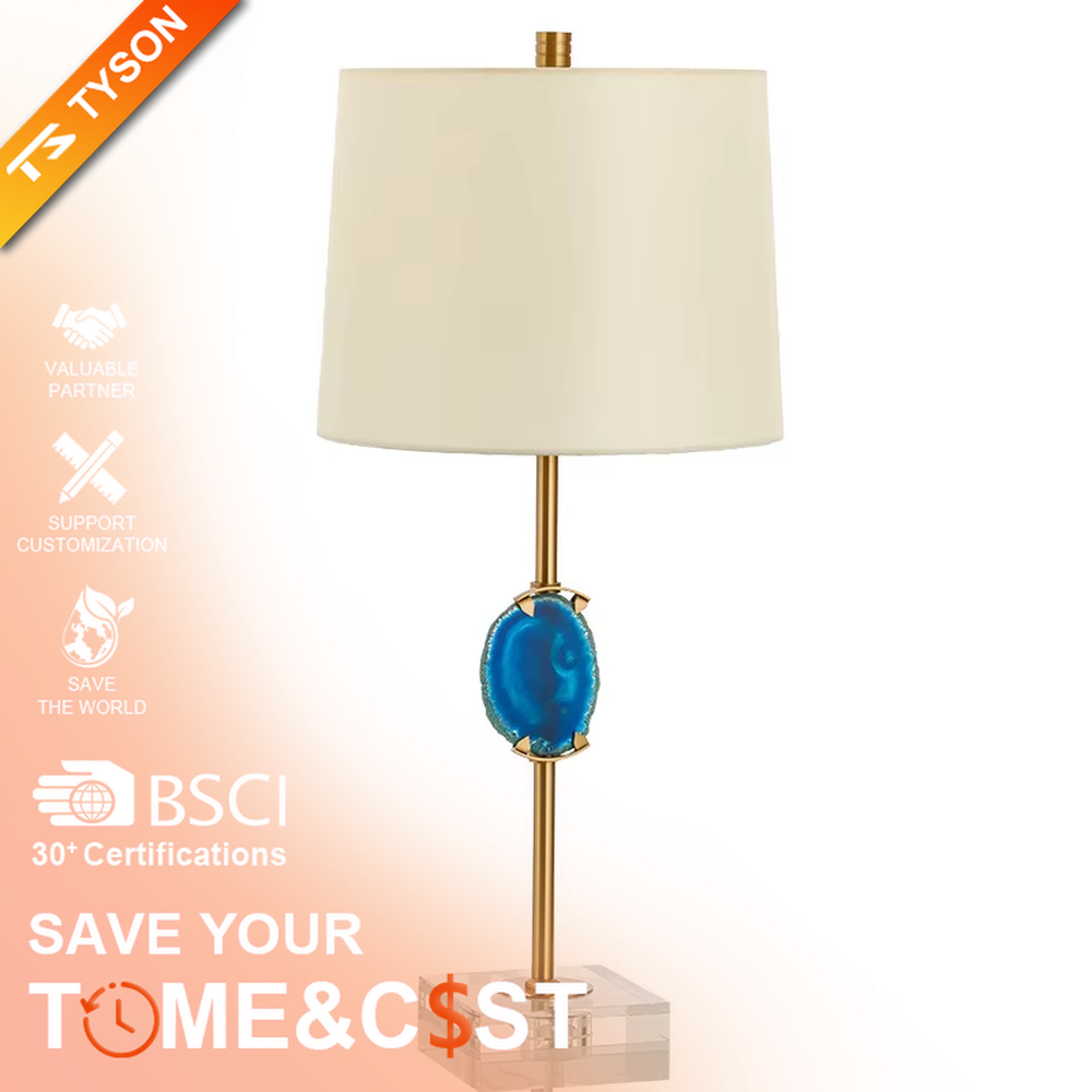This is a light luxury agate decorative table lamp, with an off-white fabric lampshade paired with a gold metal lamp pole, inlaid with a natural blue agate slice in the middle, and a transparent crystal square base, featuring both decorative and lighting functions, ideal for high-end indoor scenarios such as bedroom nightstands and living room side tables.