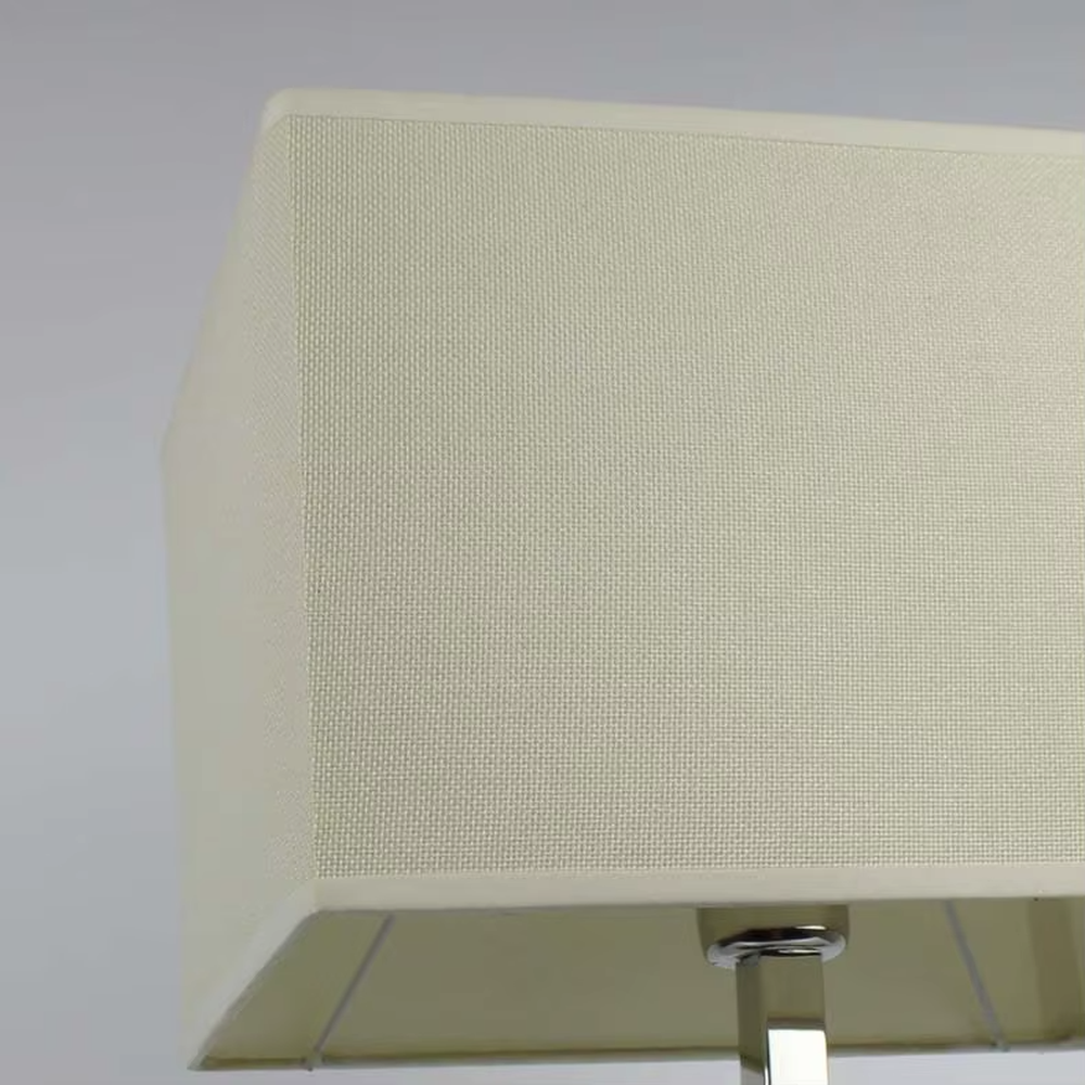 Modern minimalist geometric metal table lamp (bright chrome hollow lamp base + rectangular fabric lampshade), warm light effect, creating an exquisite and high-end home and office atmosphere.