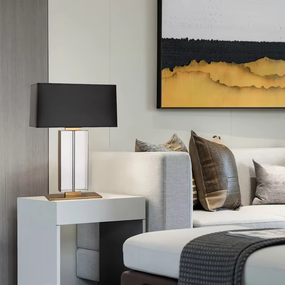 This is a modern light luxury crystal column table lamp, with a black rectangular fabric lampshade paired with a transparent cut crystal column base, accented with gold metal details, featuring both decorative and lighting functions, ideal for high-end indoor scenarios such as living room side tables and bedroom nightstands.