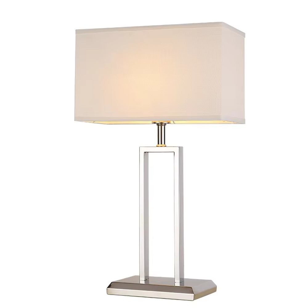Modern minimalist table lamp with a chrome-plated metal frame and a rectangular off-white fabric lampshade, emitting soft and warm light. It is both decorative and practical, suitable for lighting and decoration in living rooms, bedrooms, studies and other spaces.