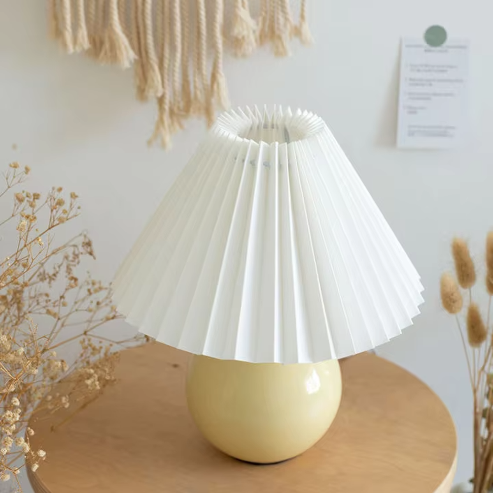 Fresh pleated umbrella shade table lamp (cream yellow glaze ball body + white pleated shade), warm light effect, creating a soft and healing home atmosphere.
