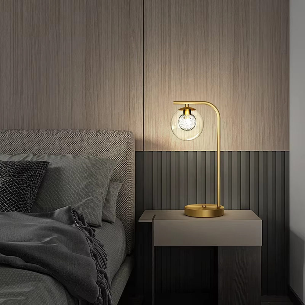 Modern light luxury golden curved pole transparent glass ball shade glitter bulb table lamp, warm light effect, creating a minimalist exquisite atmosphere.