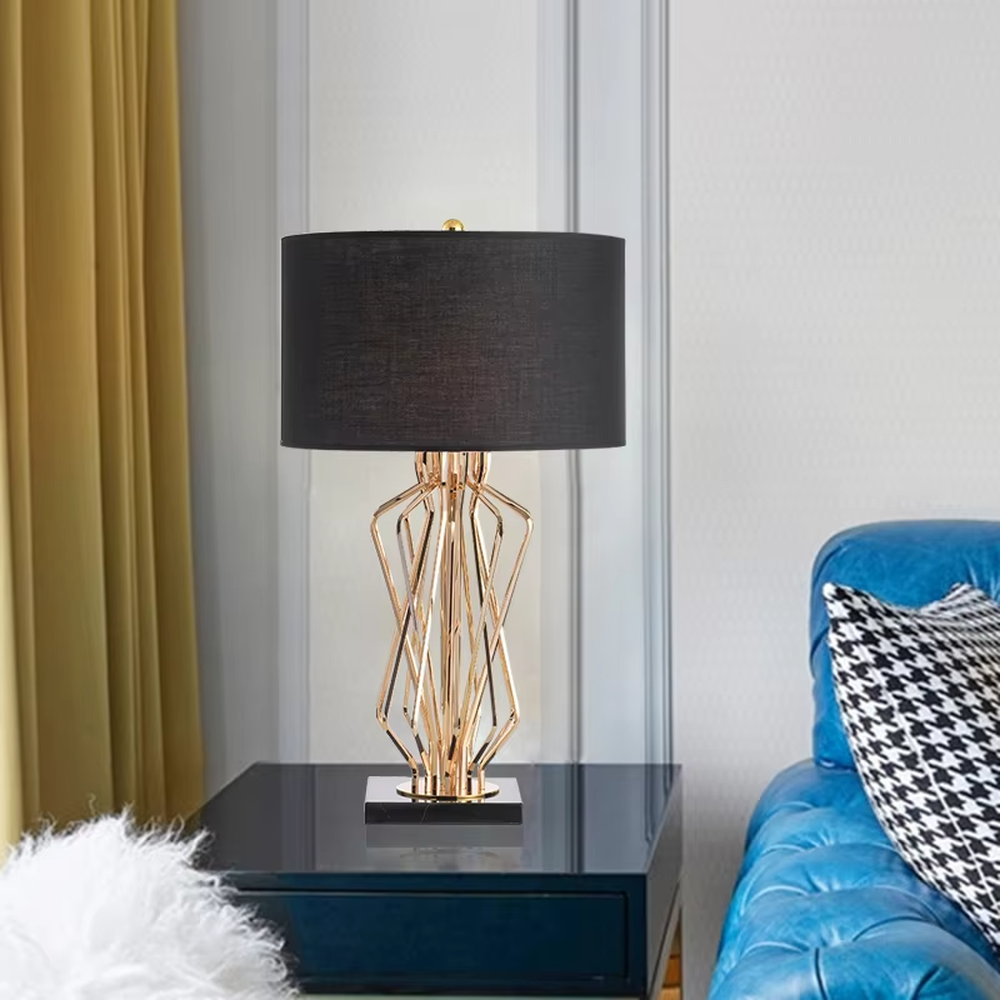 Modern luxurious black-gold geometric interwoven metal stand table lamp (black fabric lampshade + golden interwoven poles + black base), warm light effect, creating a high-end artistic atmosphere.
